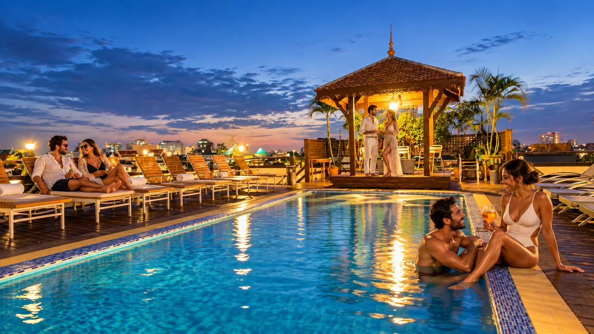 Three adult couples relaxing around the rooftop swimming pool at Khaosan Palace Hotel at twilight