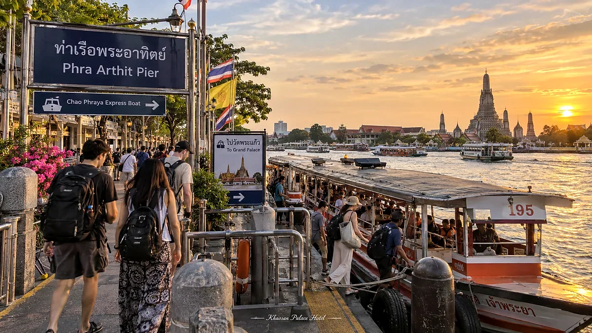 Travelers at Phra Athit Pier beside the Chao Phraya River at sunset