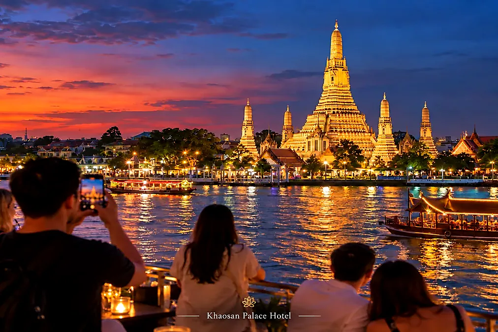 Travelers enjoying evening views of Wat Arun across the Chao Phraya River